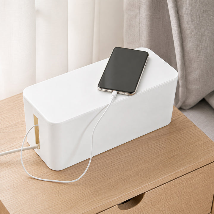 White Cable Management Box with Lid on a bedside table with a phone charging on top