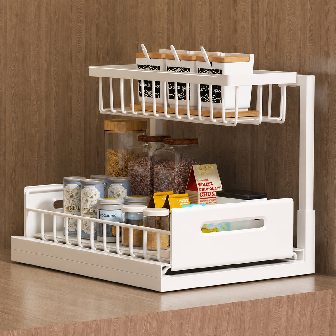 A white two-tier kitchen spice rack organizer filled with glass jars, spice boxes, and containers, set against a wood-paneled background.