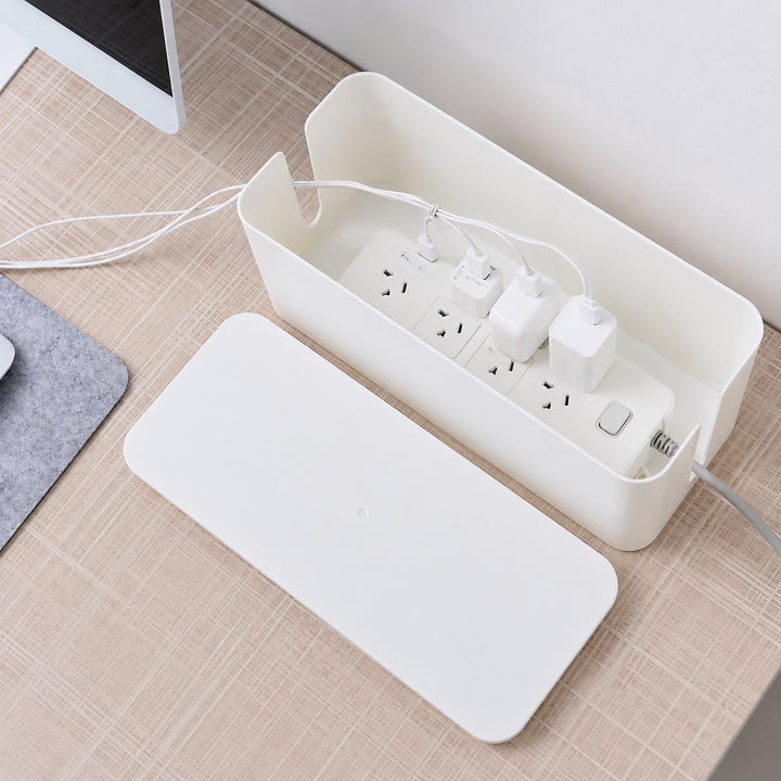 White cable management box with removable lid storing a power board and chargers on a desk